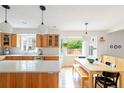 Bright kitchen featuring quartz countertops, pendant lighting, and an adjacent dining area at 5292 Lichen Pl, Boulder, CO 80301
