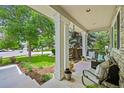 Inviting covered porch with comfortable seating, stone accents, and views of the landscaped front yard at 6105 W Long Dr, Littleton, CO 80123