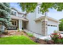 Inviting two-story home showcasing a covered porch, stone accents, manicured lawn and beautiful landscaping at 6105 W Long Dr, Littleton, CO 80123