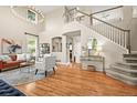 Bright, open living room with hardwood floors, a grand staircase, and large windows at 6105 W Long Dr, Littleton, CO 80123