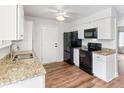 Updated kitchen boasts granite countertops, sleek black appliances, and ample white cabinetry at 16652 E Gunnison Pl, Aurora, CO 80017