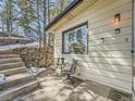 Cozy exterior patio featuring comfortable seating and a charming stone pathway leading to the entrance at 28251 Meadow Rue Rd, Evergreen, CO 80439