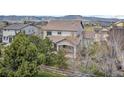 View of the private backyard with a wooden fence, mature trees, and a view of the surrounding neighborhood at 16043 Bridle Ridge Dr, Monument, CO 80132