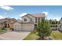 Charming stucco two-story home featuring a three-car garage, well-manicured lawn, and mature landscaping at 16043 Bridle Ridge Dr, Monument, CO 80132