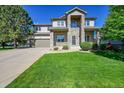 Charming two-story home with a well-manicured lawn and a stone columned porch at 8427 S Parfet Ct, Littleton, CO 80127