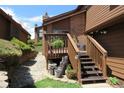 Brown home with a charming back deck, stairs, and peaceful garden area at 283 Yank Ct, Lakewood, CO 80228