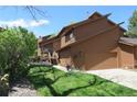 Two-story brown home with a manicured lawn, attractive landscaping and a cozy deck at 283 Yank Ct, Lakewood, CO 80228