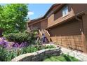 Landscaped front yard with flower beds and a charming walkway leading to the entrance at 283 Yank Ct, Lakewood, CO 80228