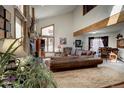 Bright living room boasts a high ceiling, large windows, fireplace, and comfortable leather seating at 283 Yank Ct, Lakewood, CO 80228