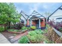 Charming home with colorful landscaping, brick accents, and a covered porch at 4467 W 30Th Ave, Denver, CO 80212