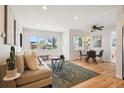 Open-concept living room features hardwood floors, large window and adjacent dining area at 2285 Fulton St, Aurora, CO 80010