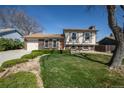 Charming brick and siding two-story home with a well-manicured lawn, flower bed, and attached garage at 1838 Cedar St, Broomfield, CO 80020