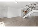 Open-concept space with hardwood floors, a staircase, and a glimpse of the kitchen at 8678 Mariposa St, Thornton, CO 80260