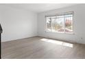 Sunlit living room featuring wood floors, a large window, and neutral-toned walls at 8678 Mariposa St, Thornton, CO 80260