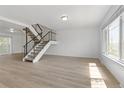 Bright living room with a staircase, hardwood floors, and natural light from a large window at 8678 Mariposa St, Thornton, CO 80260