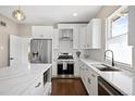 Updated kitchen featuring stainless steel appliances, an island with marble countertops and white cabinetry, plus a subway tile backsplash at 1534 Meade St, Denver, CO 80204