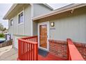 The front entrance boasts stylish wood door and red steps at 8595 Field Ct, Arvada, CO 80005