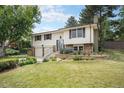 Traditional two-story house with a brick chimney and landscaping at 10473 W Arkansas Dr, Lakewood, CO 80232