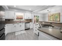 Bright kitchen featuring white cabinets, stainless steel appliances, and wood flooring at 10473 W Arkansas Dr, Lakewood, CO 80232