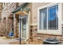 Charming condo entrance featuring stone accents, neutral siding, and a well-maintained walkway at 9390 W Chatfield Pl # 108, Littleton, CO 80128