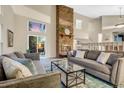 Inviting living room with a brick fireplace, comfortable sofas, and sliding doors to the patio at 8940 W 80Th Dr, Arvada, CO 80005
