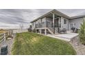 Landscaped backyard with patio, steps and black metal railing overlooking lawn at 5775 Pinto Valley St, Parker, CO 80134
