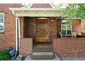 Inviting front entry with a charming brick facade, wooden door, and cozy front porch at 1434 Clermont St, Denver, CO 80220
