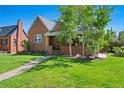 Charming two-story brick home with mature trees and a well-manicured lawn at 1434 Clermont St, Denver, CO 80220