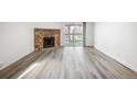 Spacious living room featuring a stone fireplace, wood floors, and natural light at 8225 Fairmount Dr # 10-204, Denver, CO 80247