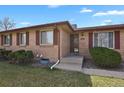 Welcoming entryway to a classic brick home with well-maintained landscaping at 65 Reed St, Lakewood, CO 80226