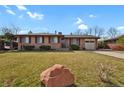 Lovely brick home featuring an attached garage and well-maintained front lawn at 65 Reed St, Lakewood, CO 80226