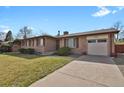 Charming single-story brick home with an attached garage and mature landscaping at 65 Reed St, Lakewood, CO 80226