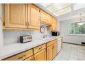 Functional kitchen featuring wood cabinets, white countertops, and tile flooring at 5190 W Mexico Ave, Denver, CO 80219