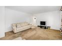 Cozy living room with neutral tones, comfortable sofa, and a TV set at 5190 W Mexico Ave, Denver, CO 80219