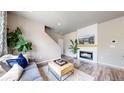 Cozy living room boasts a modern fireplace, wood floors, and plenty of natural light at 1933 Villageview Ln, Castle Rock, CO 80104