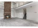 Spacious living room with a cozy fireplace and staircase leading to the upper level at 8236 E Phillips Pl, Centennial, CO 80112