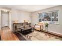 Bright living room with a large window, hardwood floors, comfortable seating, and a stylish area rug at 3083 S Xanthia St, Denver, CO 80231