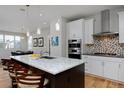 Bright, modern kitchen with quartz countertops, stainless steel appliances, and an island with bar seating at 719 Robert St, Longmont, CO 80503