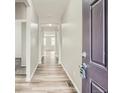 Hallway showcasing wood-look flooring and neutral wall paint, with a view of the home's open layout at 13667 Valentia St, Thornton, CO 80602