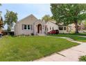 Landscaped lawn with a lovely stucco home featuring an arched entryway and a vibrant green yard at 848 Harrison St, Denver, CO 80206
