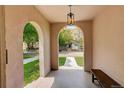 Arched porch featuring stone floors and bench seating with views to the tree lined street at 848 Harrison St, Denver, CO 80206