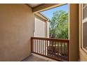 Balcony view with wood railing overlooking lush greenery, creating a serene outdoor space at 10578 E Jewell Ave, Aurora, CO 80012
