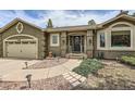 Inviting front entrance of a single-story home with lush landscaping and sidewalk at 19475 Stag Ln, Monument, CO 80132
