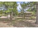 Single story home with lush landscaping and mature trees surrounding the exterior at 19475 Stag Ln, Monument, CO 80132