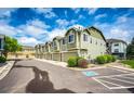 Modern townhome exteriors showcase attached garages and manicured greenery, set beneath a sunny blue sky at 15955 E Geddes Dr # 55, Aurora, CO 80016