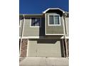 Attached garage with brick accents and a wide driveway providing ample parking space for residents and guests at 15955 E Geddes Dr # 55, Aurora, CO 80016