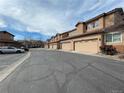 View of several townhome garages, with tan exteriors and matching garage doors, set against a blue sky and tree line at 4519 S Atchison Way, Aurora, CO 80015