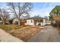 Front yard featuring a well-maintained lawn and driveway leading to a detached garage at 2020 Gray St, Edgewater, CO 80214