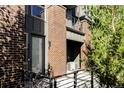 Contemporary townhome entrance with brick accents, a sleek black railing, and modern door at 5036 S Platte River Pkwy, Littleton, CO 80123