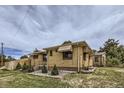 Exterior view of the house with a well-kept lawn and trees with a beautiful sky at 10600 E 25Th Ave, Aurora, CO 80010